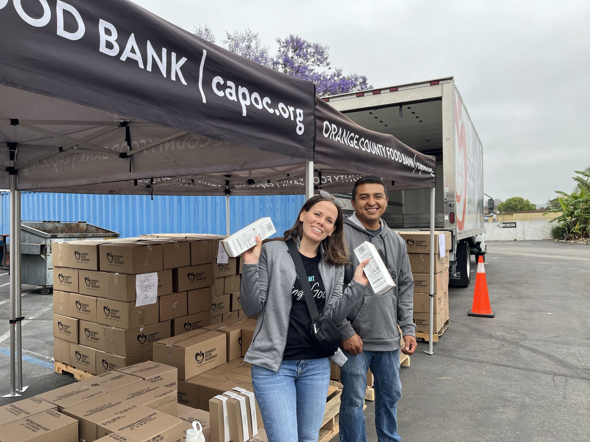 Smiling volunteers holding food boxes