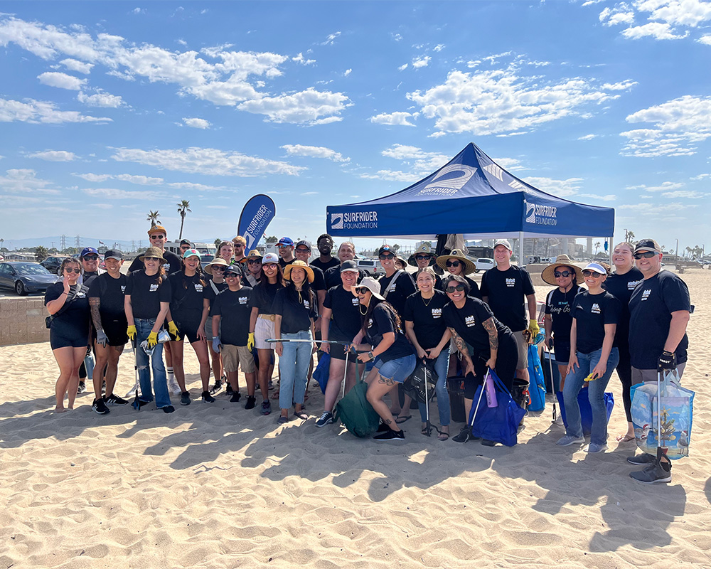 Group shot of Surfrider beach cleanup crew, with canopy in backgruond.