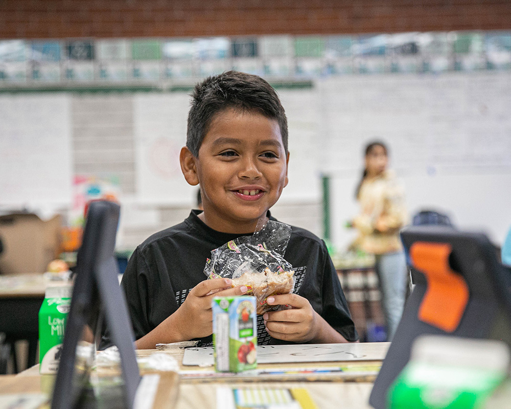 A smiling boy in the lunch room at Huron Elementary